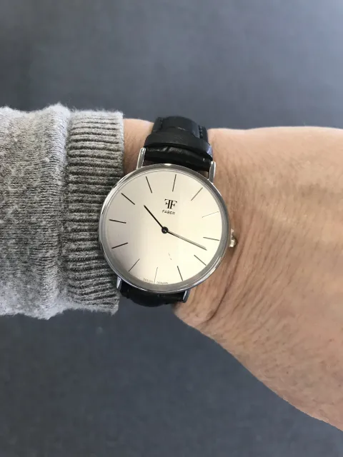 FABER-TIME - Dameur - Stål Blank m/Hvid Ursdkive Oplev tidløs elegance med FABER-TIME dameuret. Dette smukke ur kombinerer klassisk design med moderne detaljer. Det er fremstillet i blankt stål, der giver et stilrent og luksuriøst look, der kan bæres både til hverdag og fest. Den hvide urskive tilføjer et friskt og let udtryk, mens de diskrete time- og minutmarkeringer sikrer nem aflæsning af tiden. FABER-TIME dameuret er ikke bare et praktisk tilbehør, men også et statement. Det perfekte valg til den stilbevidste kvinde, der ønsker et ur, der både er funktionelt og samtidig underbygger hendes personlige stil. Uanset om du ønsker at opgradere din egen samling eller give en gave, der vækker glæde, er dette ur en uundværlig klassiker. Specifikationer: Materiale: Blank stål Ursdskive: Hvid Design: Elegant og tidløst Mål: Passer perfekt til det feminine håndled Anledning: Daglig brug eller festlige lejligheder Gør dit håndled endnu smukkere med FABER-TIME – en investering i både stil og kvalitet.